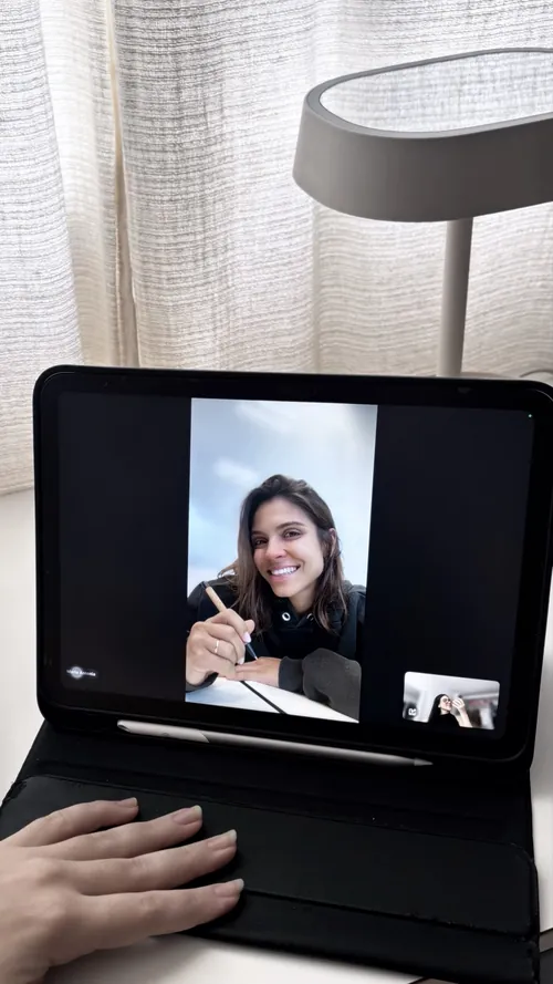 Maria Antônia sorrindo em uma videochamada, na tela de um tablet